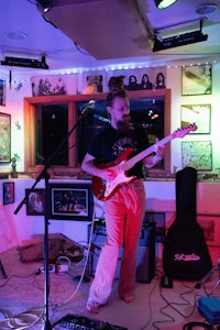 a man is playing a guitar in a room