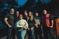 a group of people standing in front of a cabin